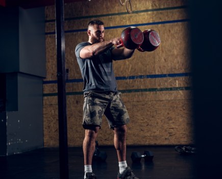 man performing double kettlebell swing