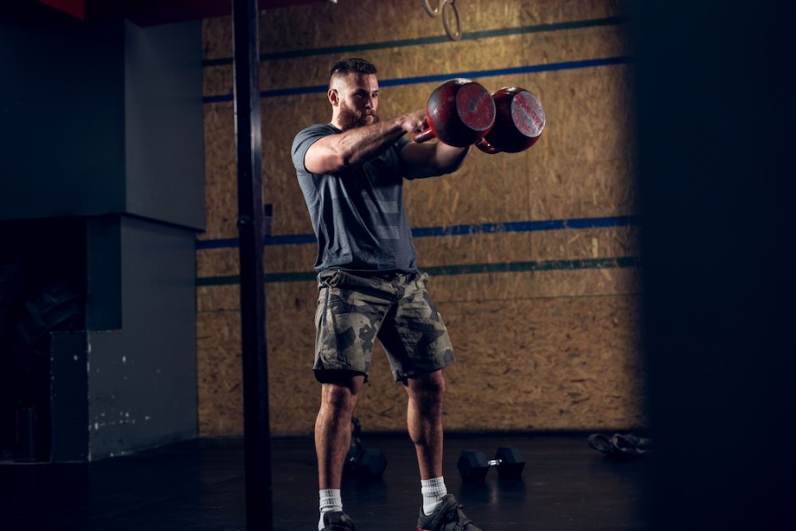 man performing double kettlebell swing