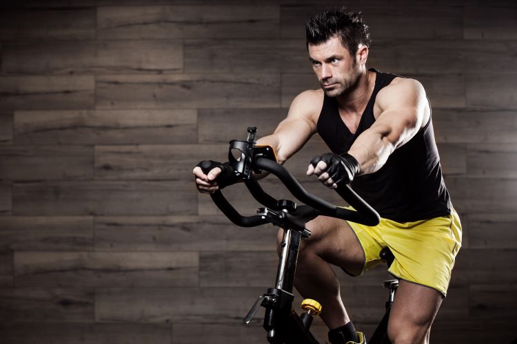 Upper torso of a man riding an exercise bike