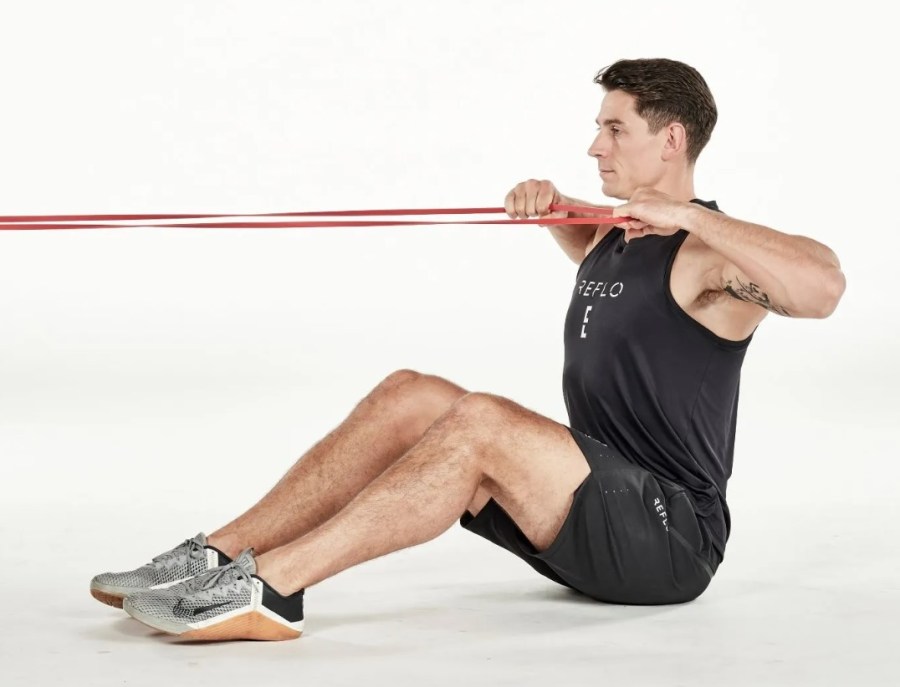 Man performing a seated resistance band exercise
