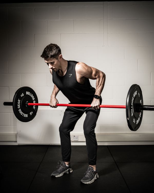 A man lifting a barbell with rubber weight plates