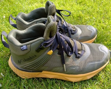 A worn pair of hiking boots on grass