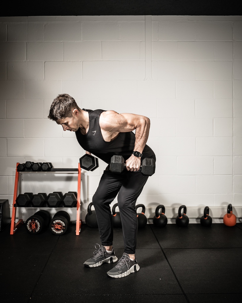 Personal trainer demonstrating how to do a dumbbell bent-over row