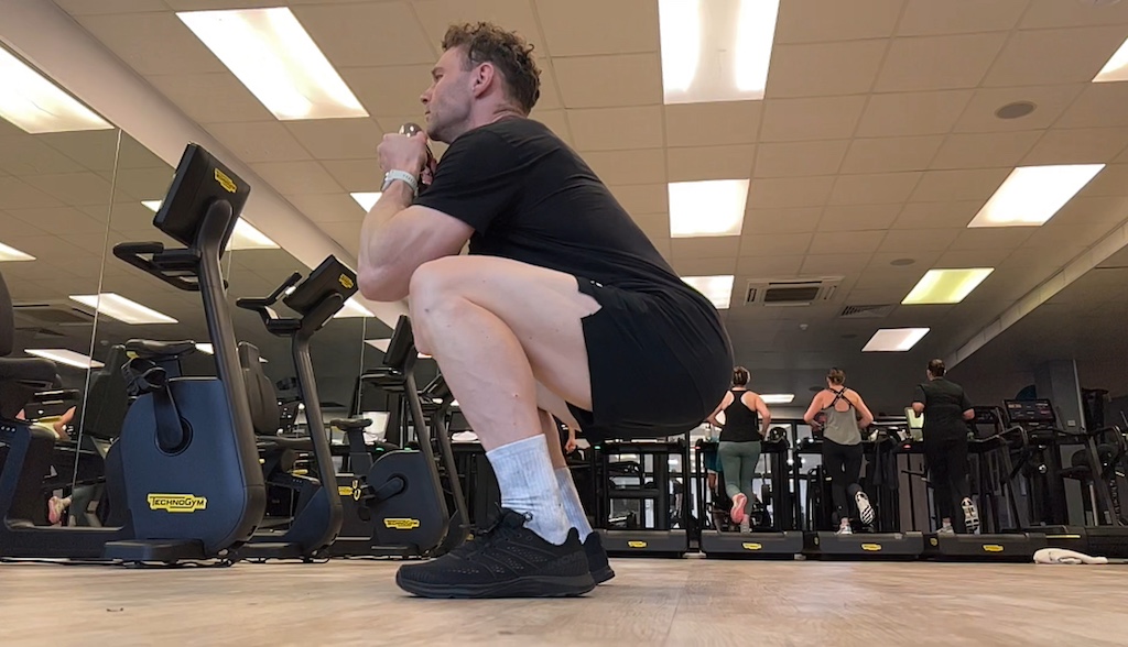 Man performing air squat in the gym