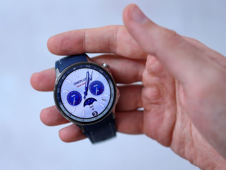 Man's hand holding a running watch