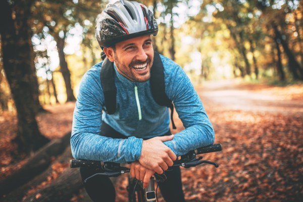 Happy male cyclist in forest