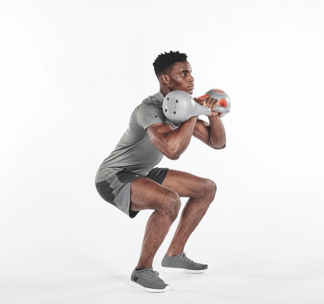 Man performing a squat with kettlebells
