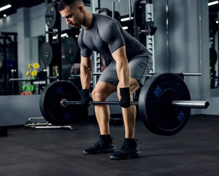 A man attempting a barbell deadlift.