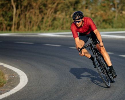 Male cyclist cornering on a road bike