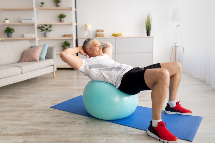 A man performing a gym ball exercise at home