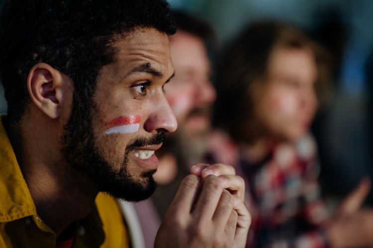 Stressed football fans watching a game on TV