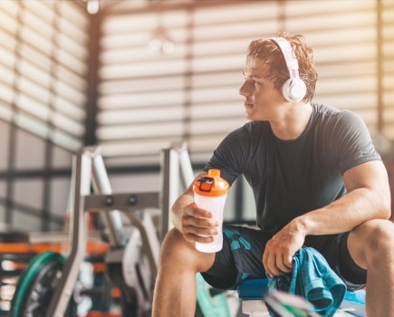 man drinking pre-workout in the gym