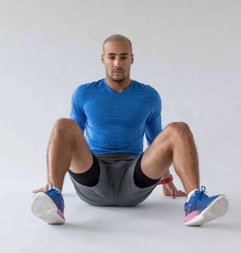 Man performing a seated 90/90 stretch