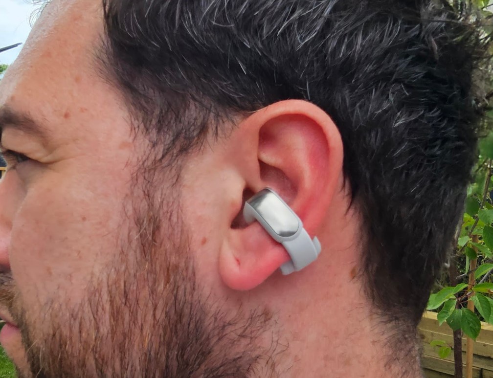 Close-up of a man's ear, with a Bose open ear earbud attached