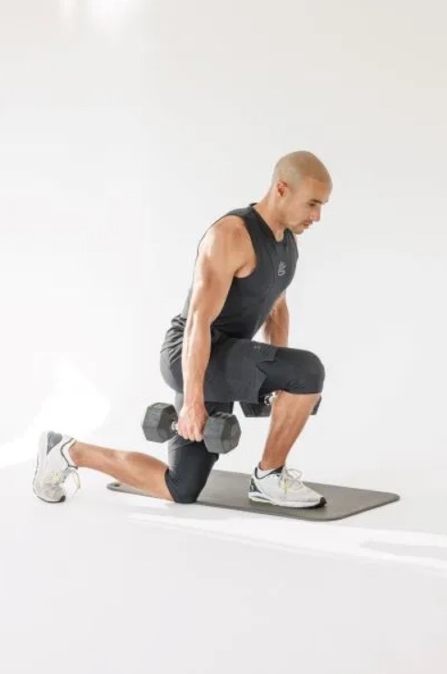 Man performing a dumbbell curtsey lunge