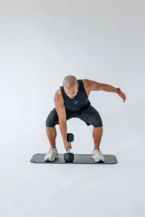 Man performing a dumbbell single-arm snatch