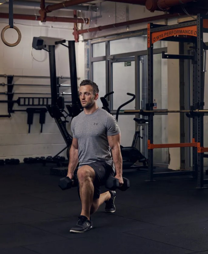 man performing dumbbell lunge