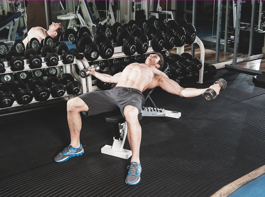 man performing incline dumbbell flye in the gym