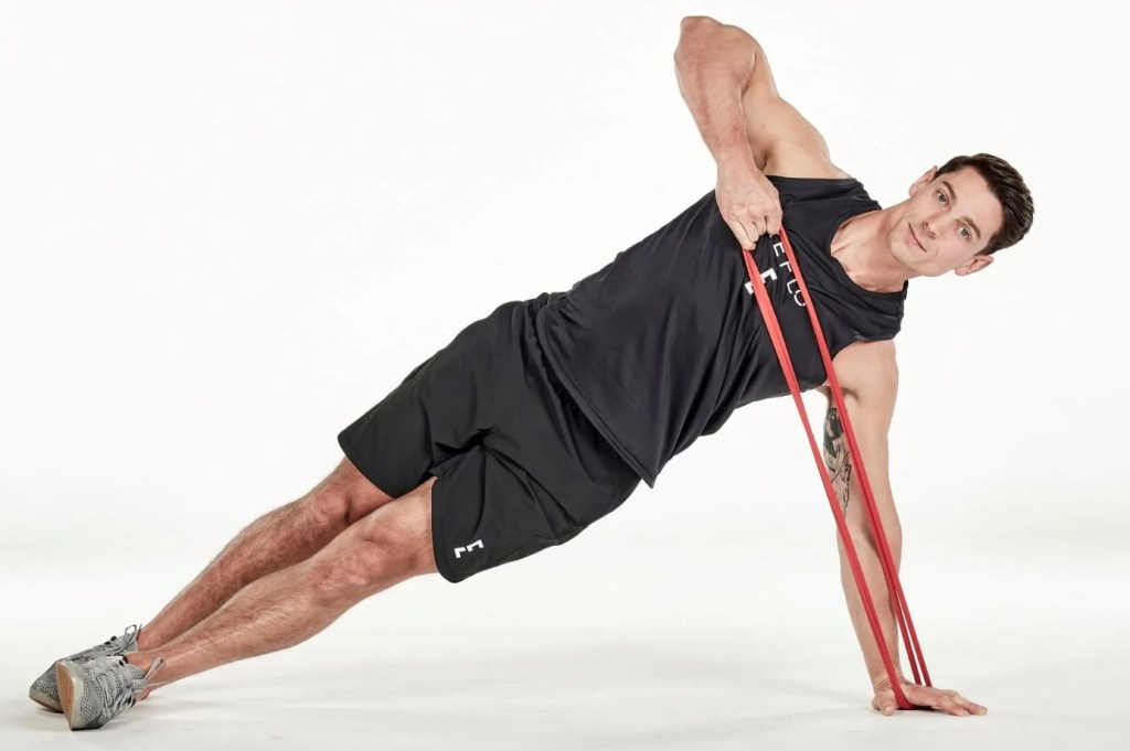 Man performing a resistance band side plank high pull
