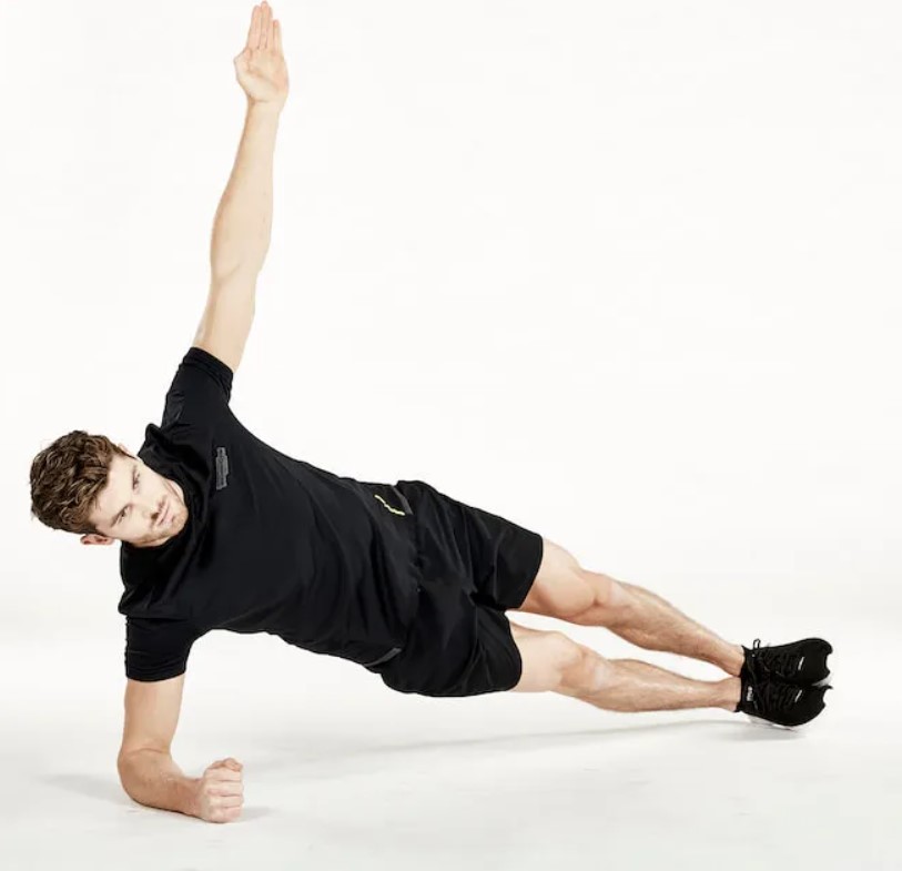 Man performing a side plank reach