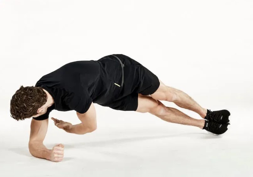 Man performing a side plank reach