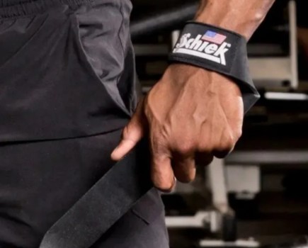 Close-up of a man's hand and Schiek lifting strap
