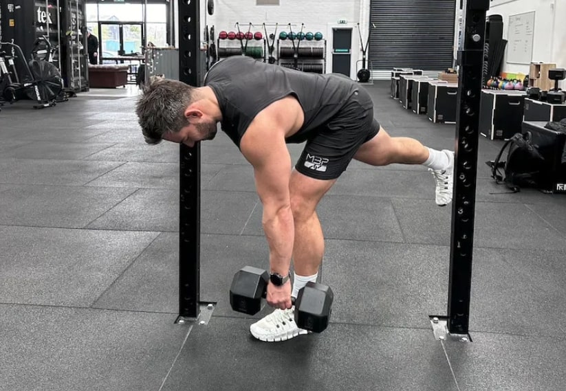 personal trainer doing single-leg RDL in a gym