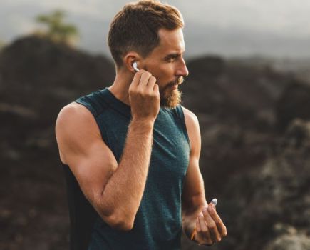 A male runner putting headphones in