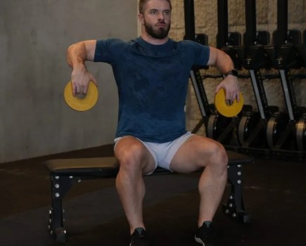 Man performing a Cuban press exercise