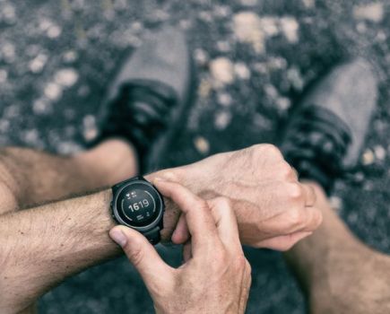 Close-up of a man's hand operating a running watch