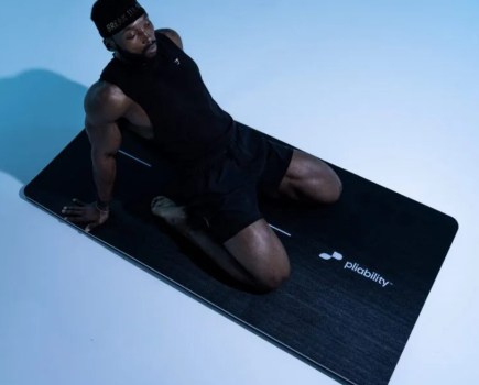 Man performing a saddle pose on an exercise mat