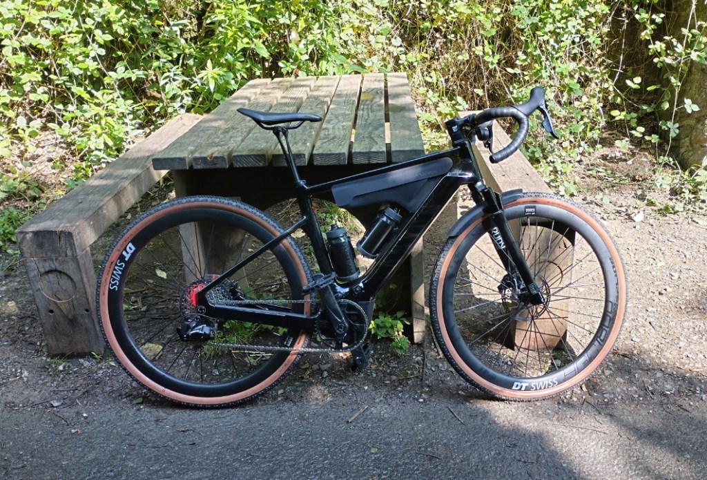 A gravel e-bike leaning on a picnic bench